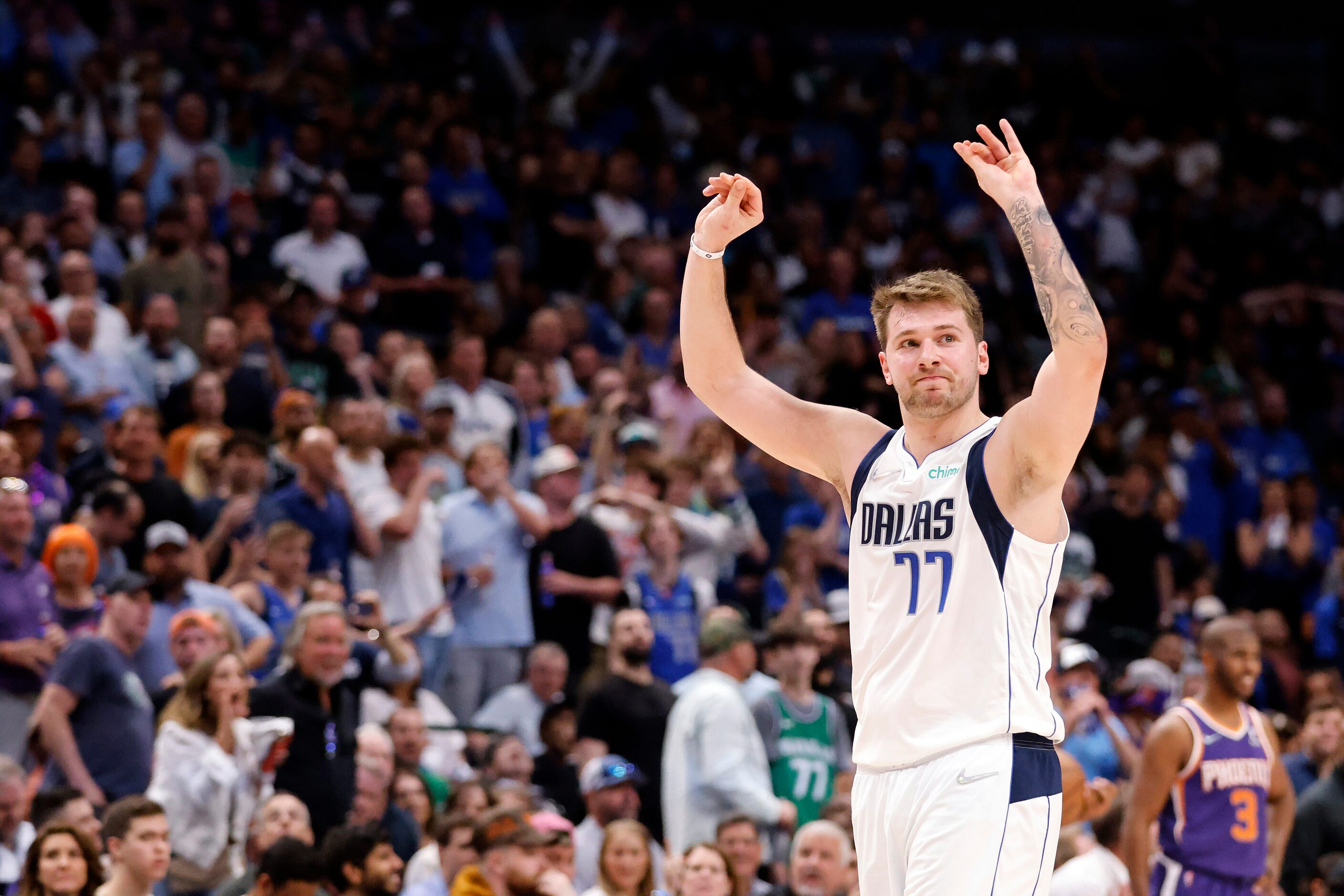 Dallas Mavericks guard Luka Doncic (77) raises his hands as he walks to the bench during the...