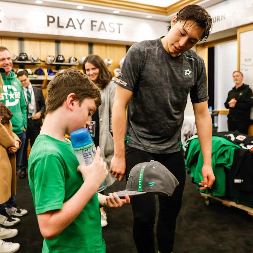 Max Hinojosa, 9, shares a moment with Dallas Stars Jason Robertson in the locker room of the...