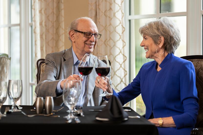 Edgemere resident Dr. Paul Radman and his partner, Jane, sitting at a table and toasting...