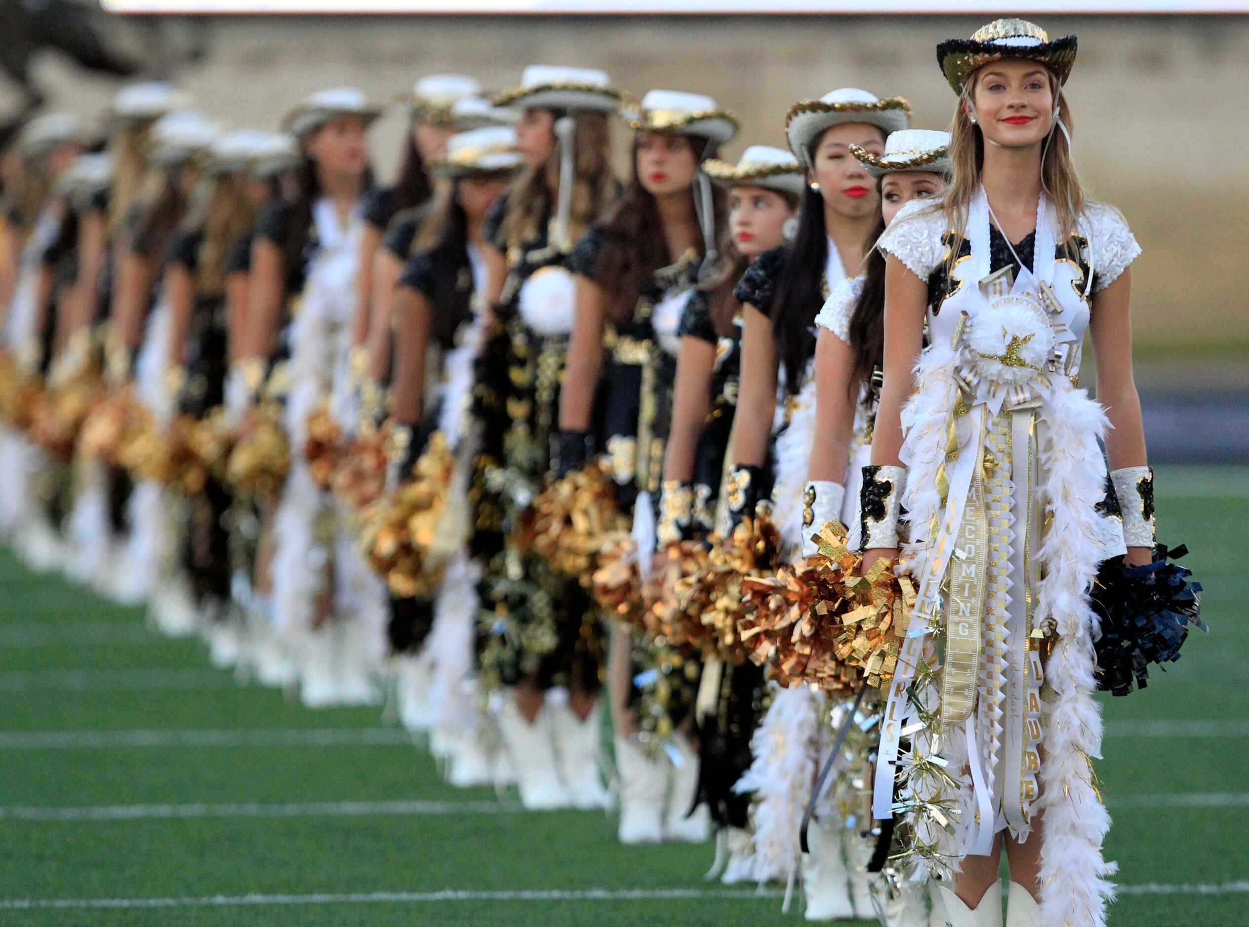 Plano East drill team members sport mums for homecoming before the start of the first half...