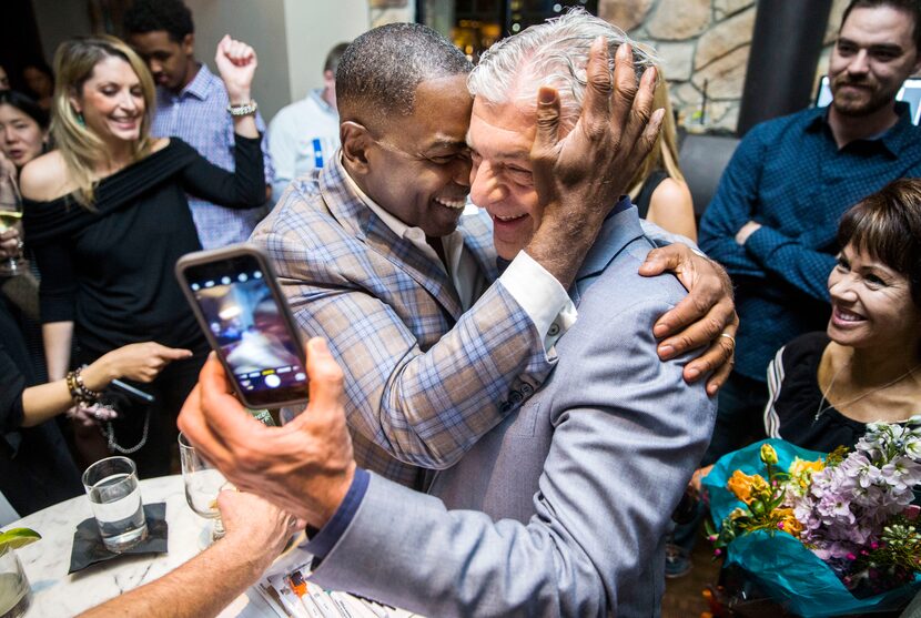 Plano mayoral incumbent Harry LaRosiliere, center left, hugs Fehmi Karahan after the...