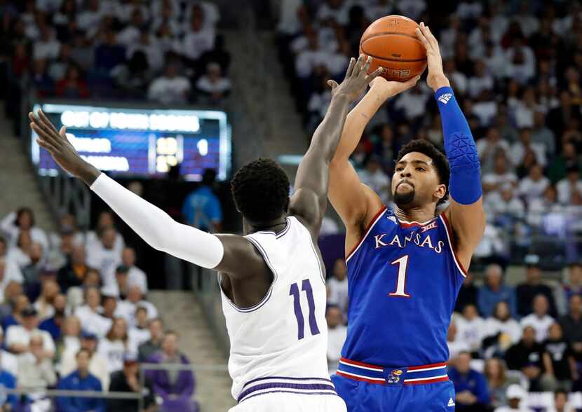 TCU forward Lat Mayen (11) defends as Kansas forward Dedric Lawson (1) attempts a shot in...