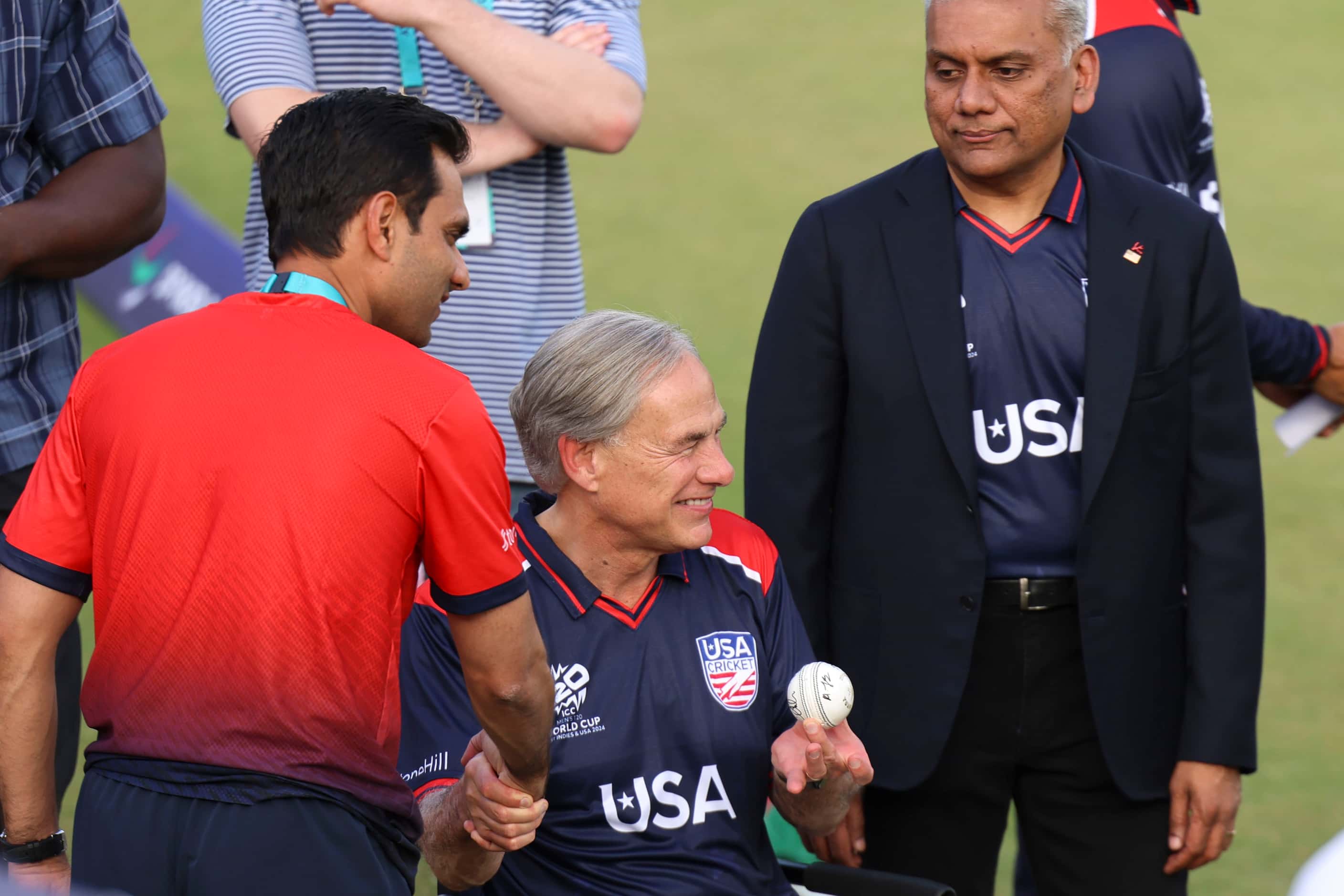 Texas governor Greg Abbott  (center) poses holding a cricket ball past Major League Cricket...