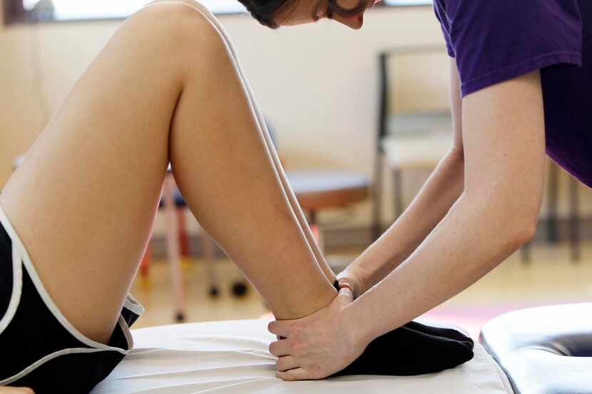 
Physical therapist Lara Trevett (right) checks the alignment of Haley Holmes’ legs at...