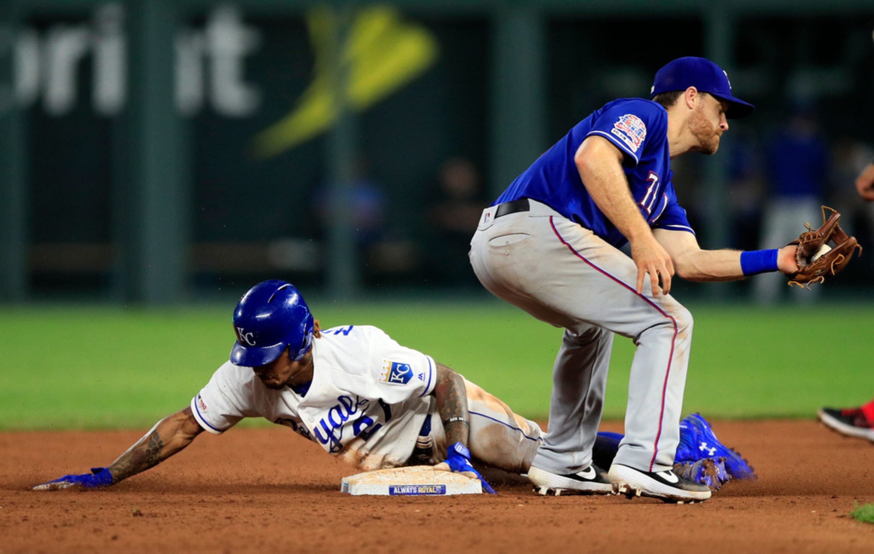 Kansas City Royals' Adalberto Mondesi, left, beats the tag by Texas Rangers shortstop Logan...