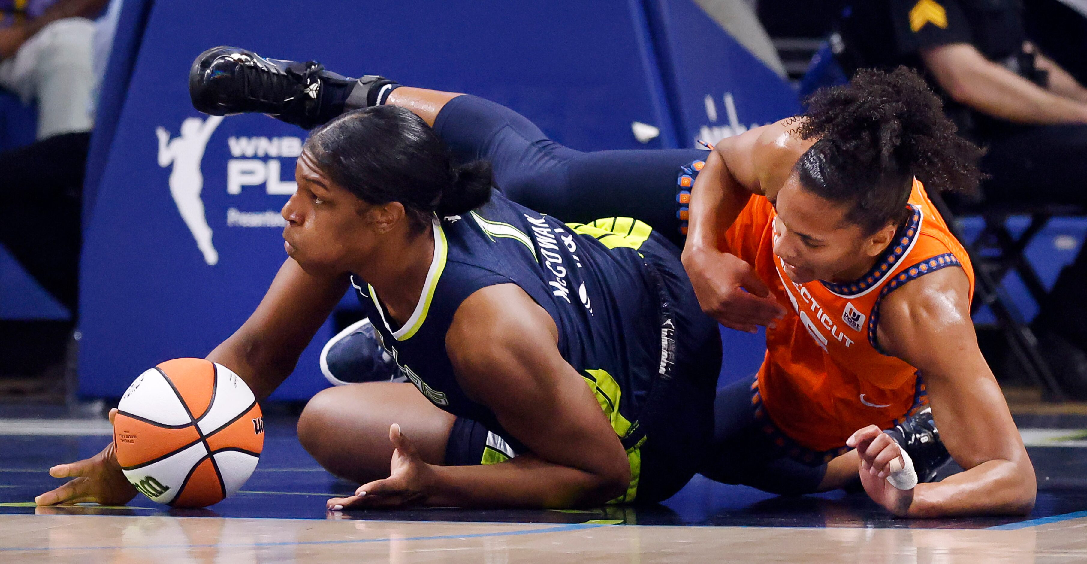 Dallas Wings center Teaira McCowan (7) covers a loose ball by Connecticut Sun forward...