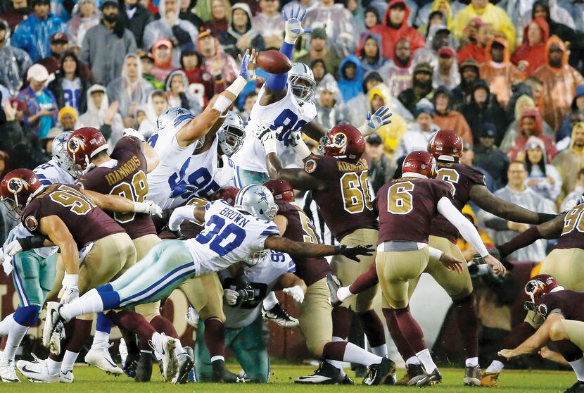 Dallas Cowboys defensive end Tyrone Crawford, with bandage on arm, blocks a field goal...