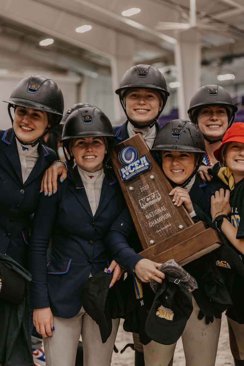 SMU equestrians hold the national championship trophy.