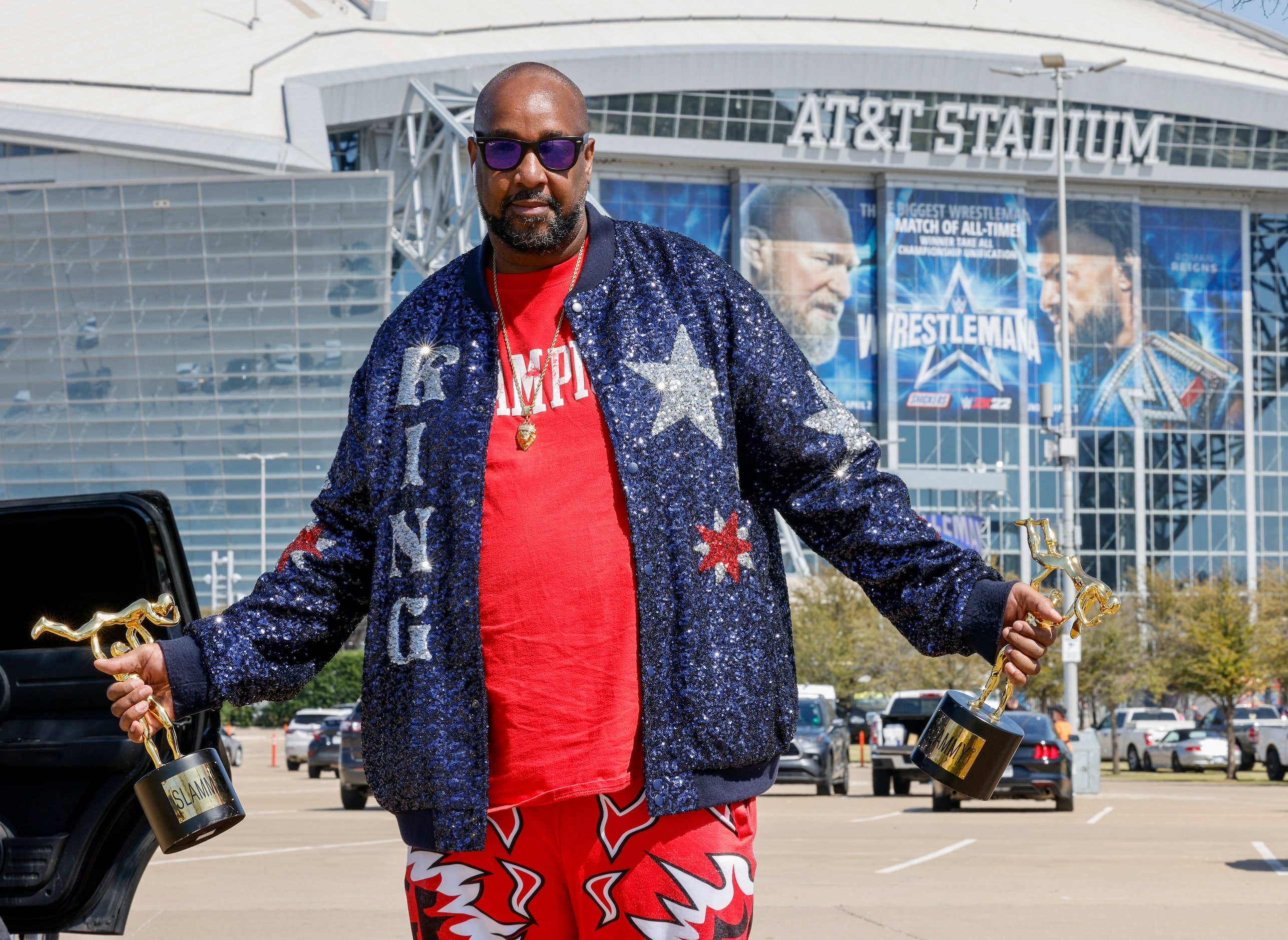 Michael Knox, 46, shows off his jacket while holding two Slammy Awards before WrestleMania...