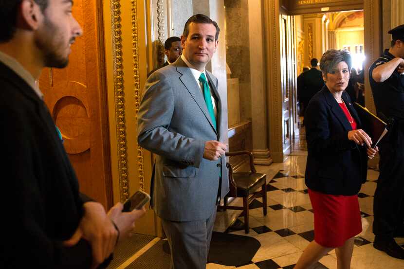 Republican Sens. Ted Cruz (center) and Joni Ernst (right) leave the Senate chamber Thursday....