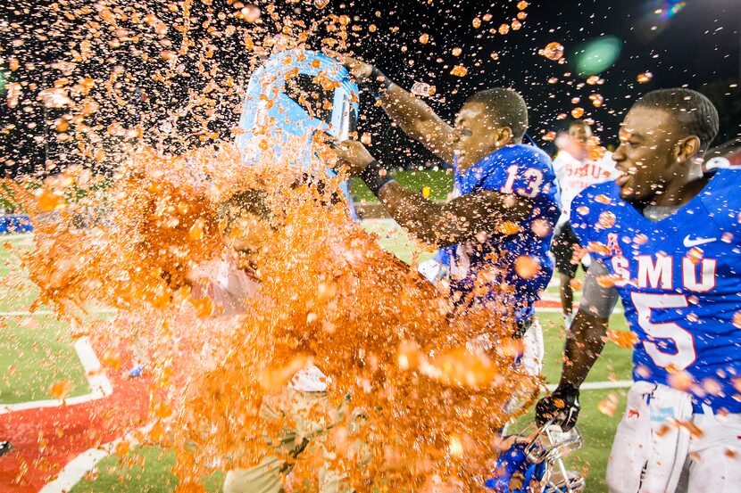 SMU wide receiver Ryheem Malone (13) dunks head coach Chad Morris with Powerade after the...