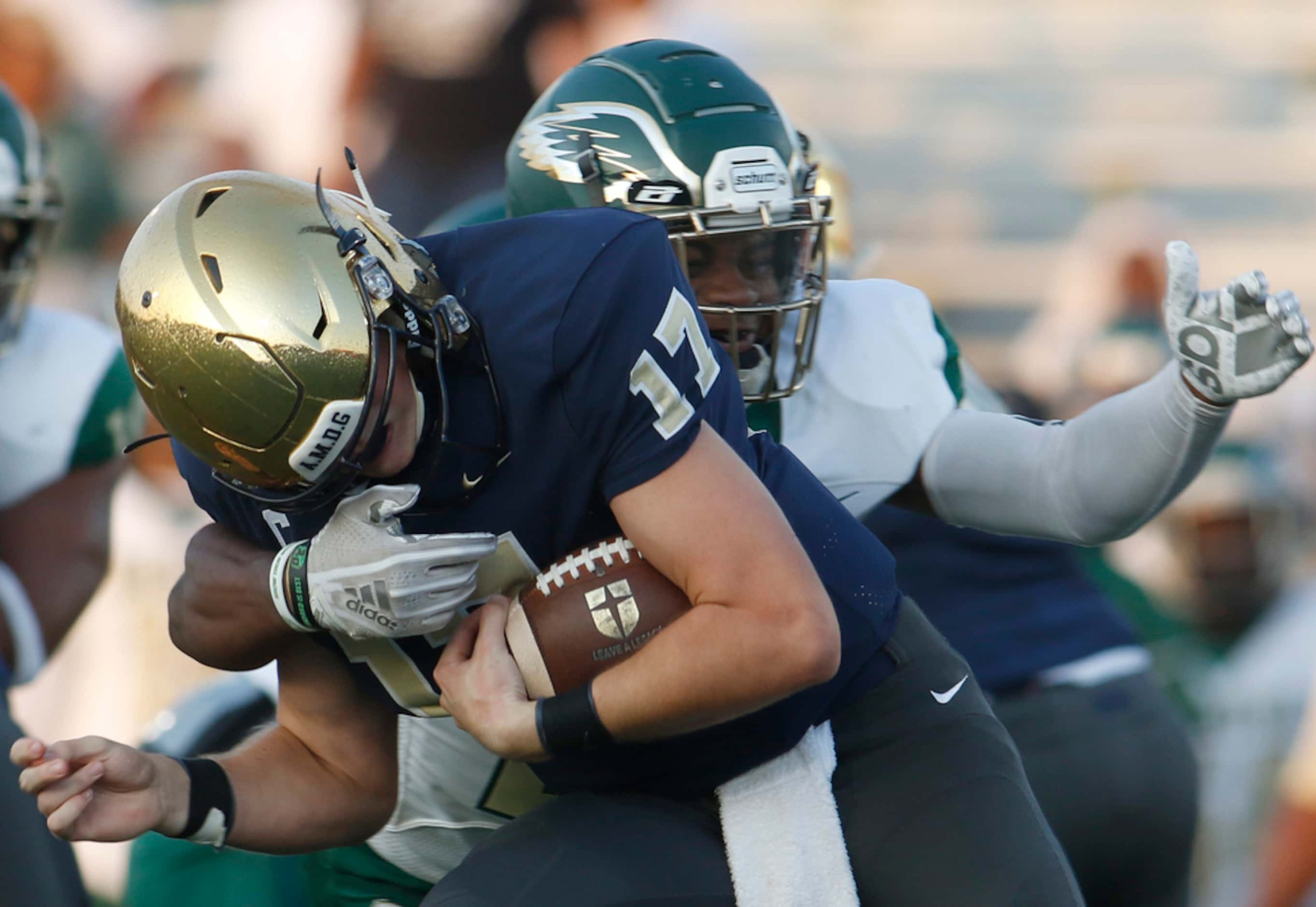 Jesuit quarterback Rance Holman (17) feels the defensive force applied by DeSoto defensive...