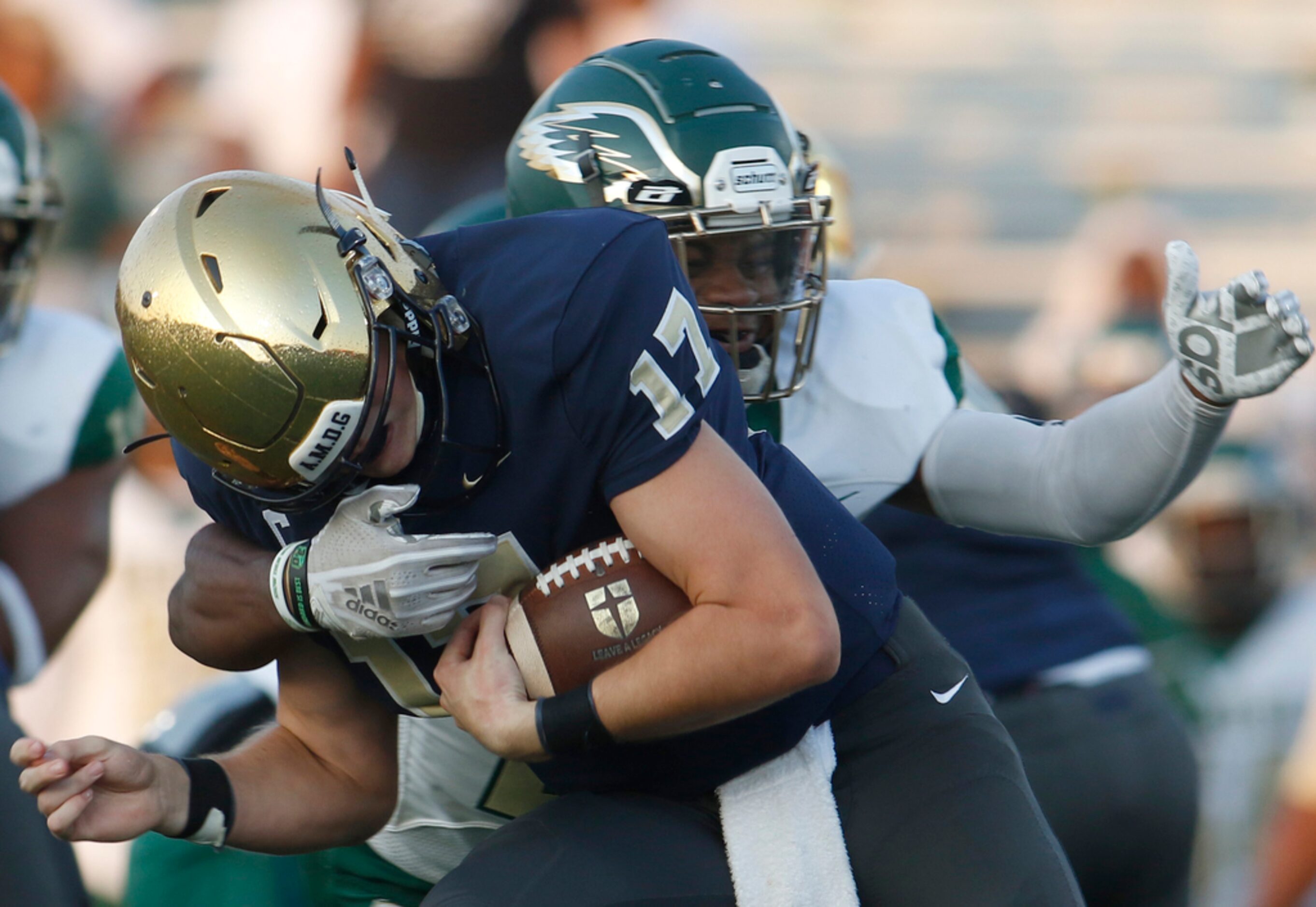 Jesuit quarterback Rance Holman (17) feels the defensive force applied by DeSoto defensive...