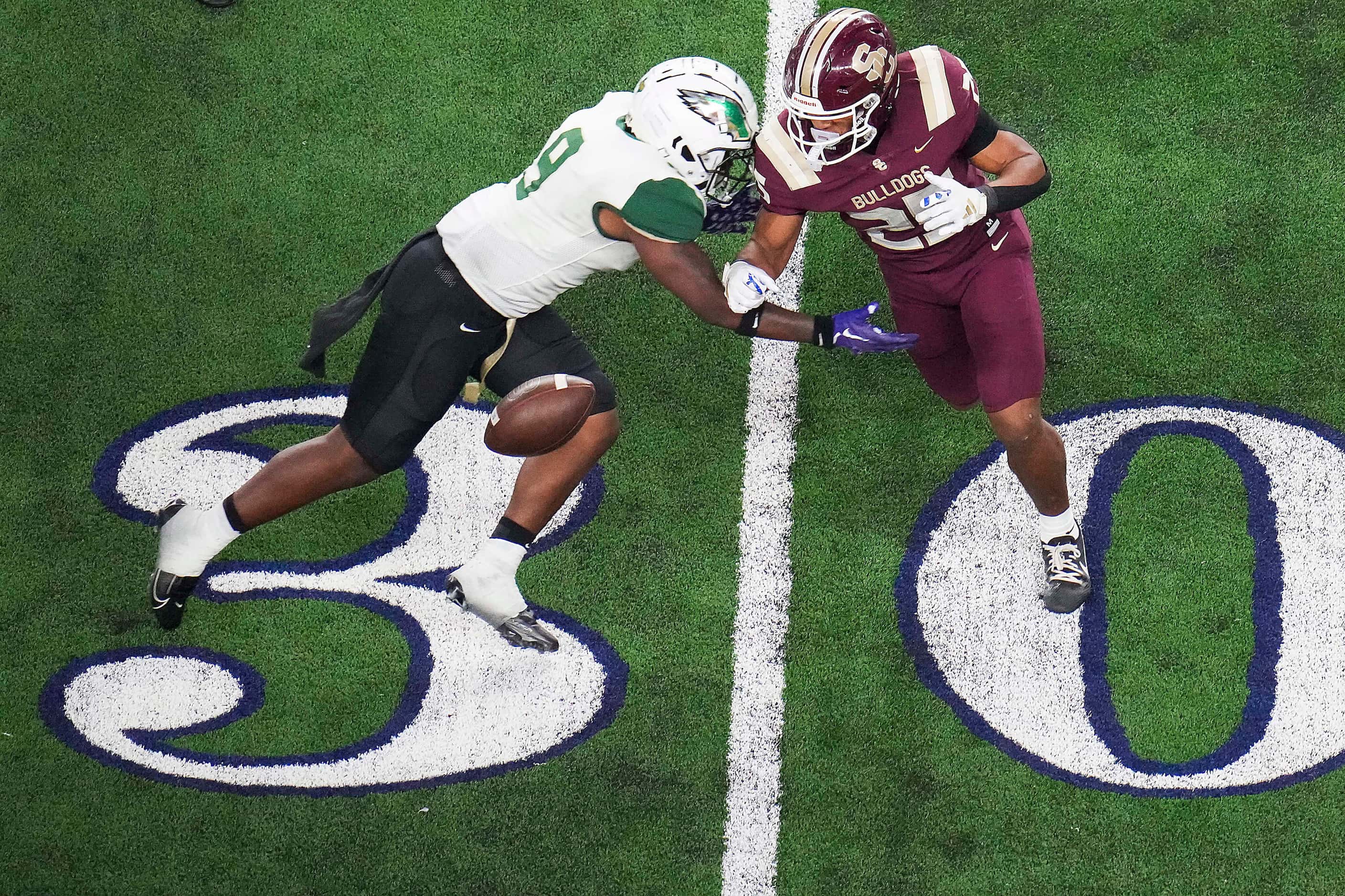 Humble Summer Creek running back Lloyd Avant (25) loses a fumble as he is hit by DeSoto...
