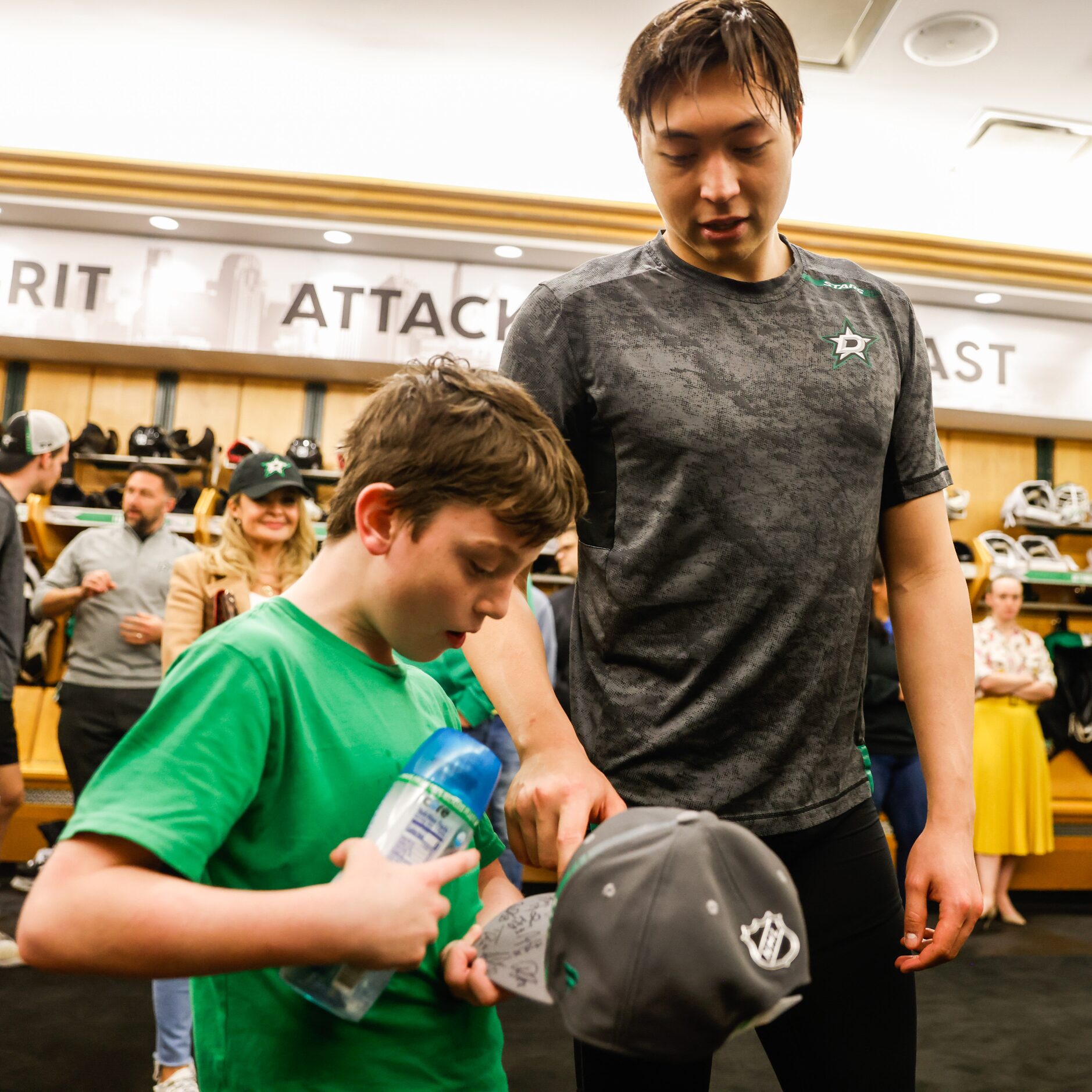 Max Hinojosa, 9, shares a moment with Dallas Stars Jason Robertson in the locker room of the...