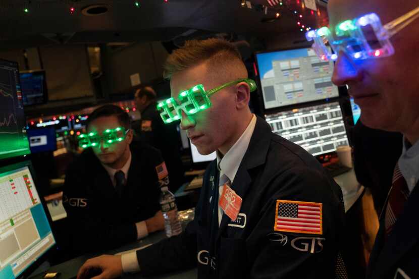 Stock traders wore New Year's 2020 party glasses Tuesday at New York Stock Exchange.