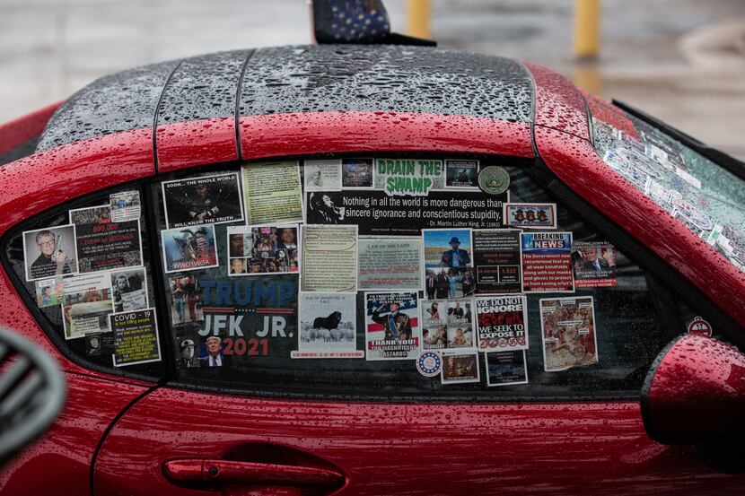 A car covered in QAnon and Trump stickers sits at a QAnon gathering at Dealey Plaza in...