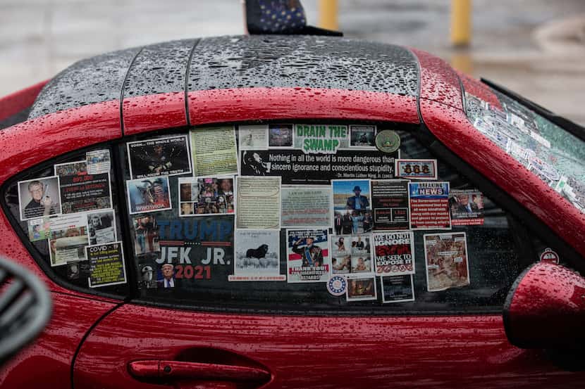 A car covered in QAnon and Trump stickers sits at a QAnon gathering at Dealey Plaza in...