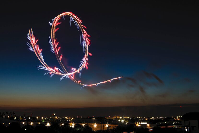 Pyrotechnics trail the path of pilot Nathan Hammond over North Texas during the annual...