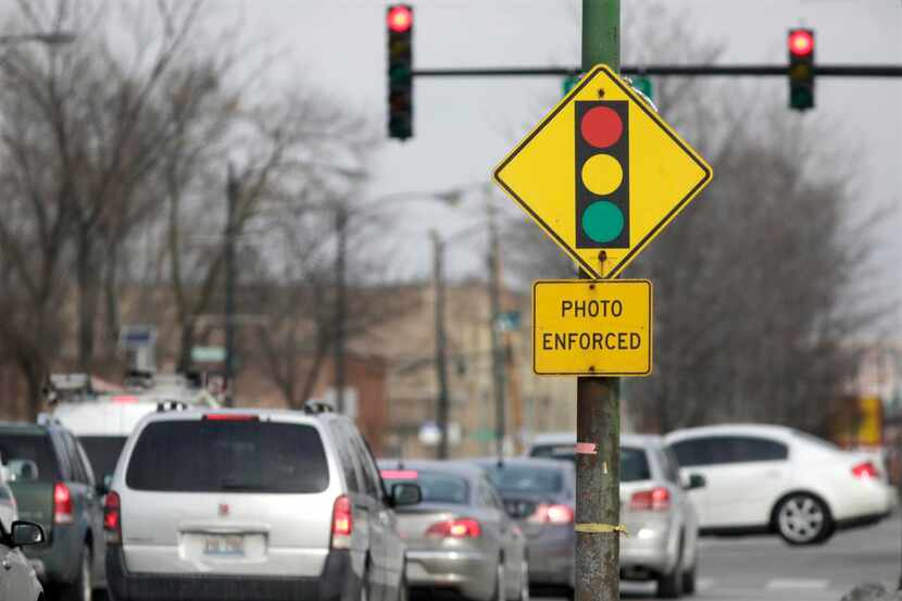
 A sign warns motorists of the presence of a red-light camera. Readers sound off about...