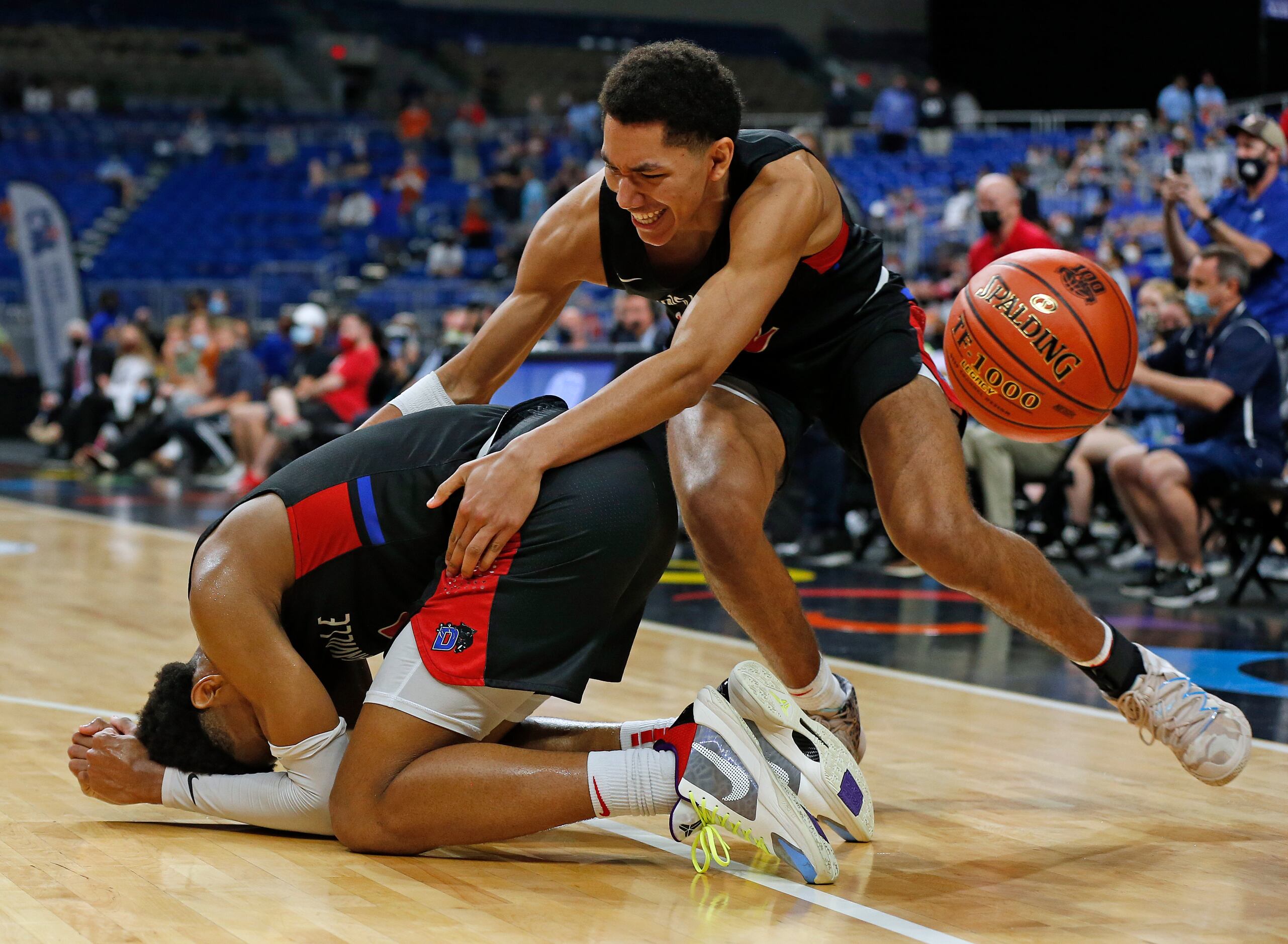 Duncanville Zhuric Phelps #0 fell to the floor as teammate Duncanville Davion Sykes #22 goes...