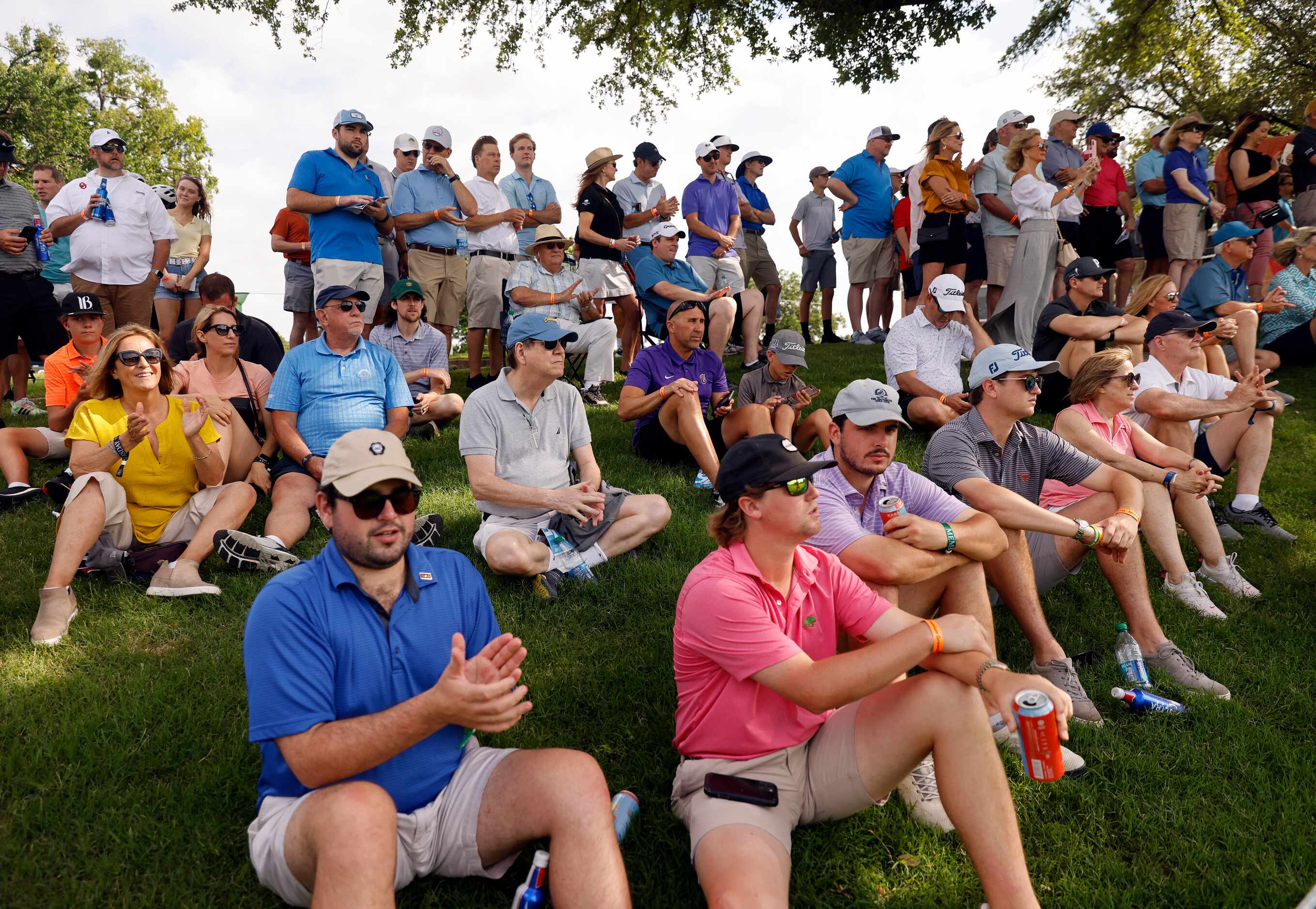 Golf fans applaud professional golfers Phil Mickelson, Jordan Spieth and Daniel Berger as...