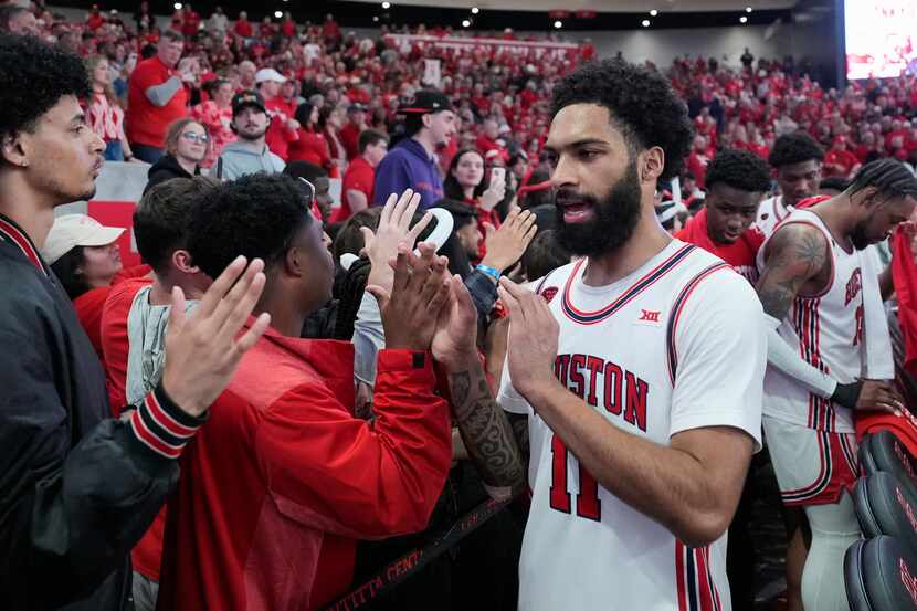 Houston's Damian Dunn (11) celebrates with fans after an NCAA college basketball game...