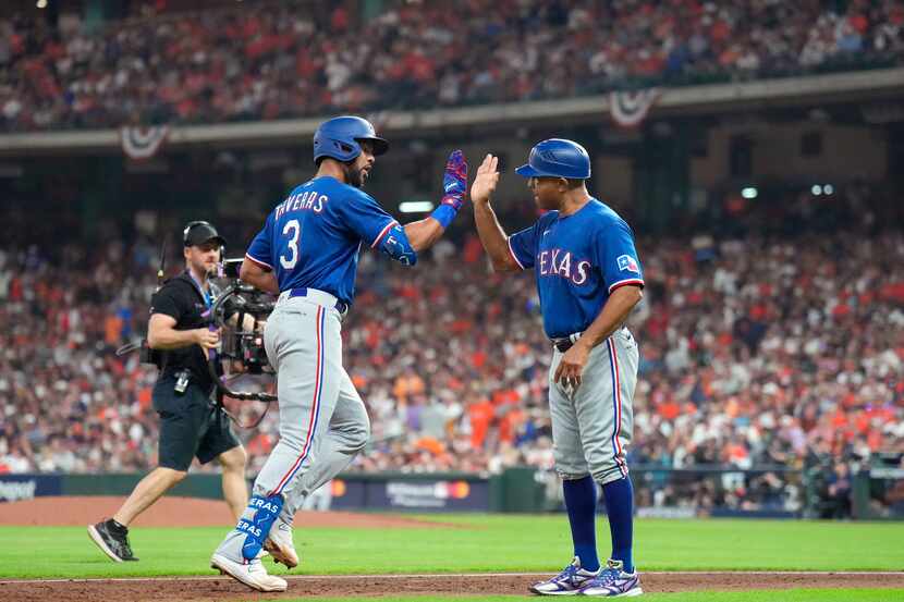 Texas Rangers batter Leody Taveras (3) receives a high-five from third base coach Tony...
