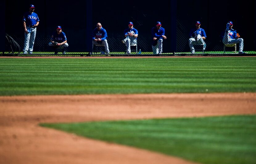 Texas Rangers watch the second inning of a spring training game against the Seattle Mariners...