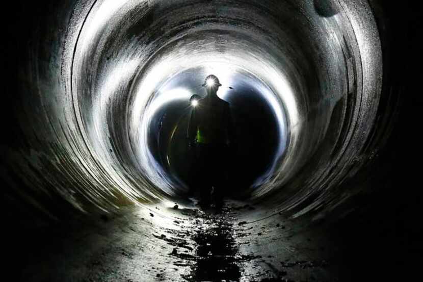 
Dallas Water Utilities workers navigate a tunnel beneath the Trinity River that will house...
