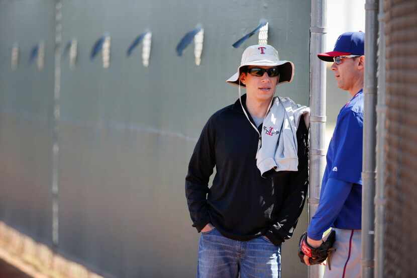 Texas Rangers general manager Jon Daniels speaks with former infielder Michael Young (right)...