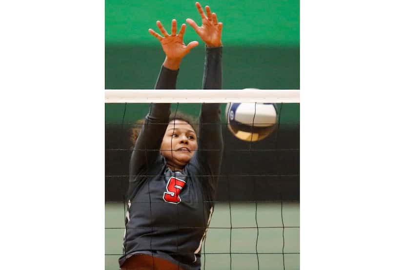 Lovejoy outside hitter Cecily Bramschreiber (5) tries to block a hit during the first set as...