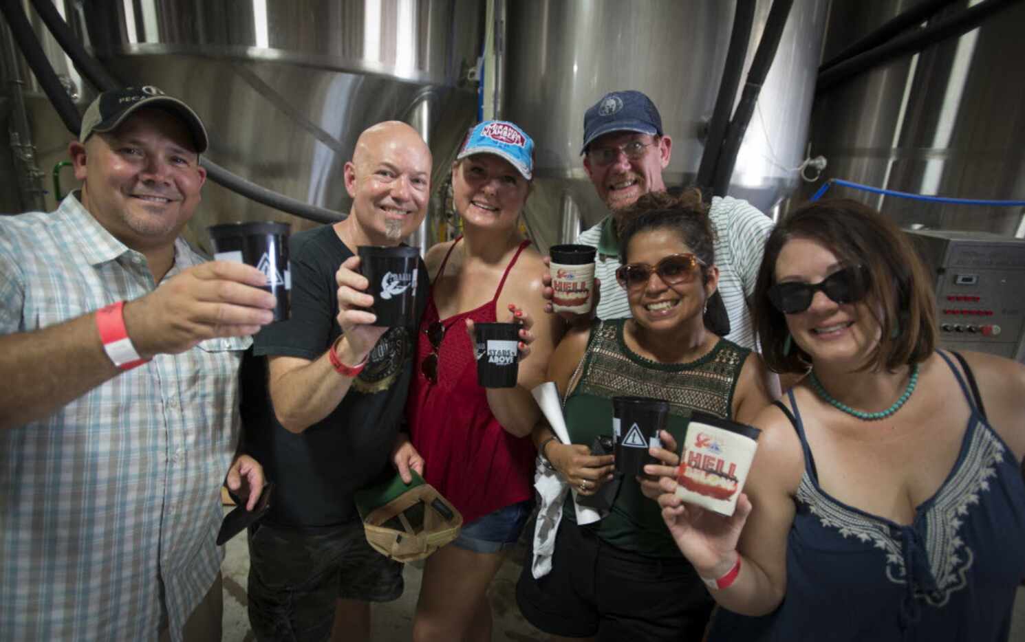 A pack of beer fans lift their cups at Martin House Brewing Company in Fort Worth, Texas on...