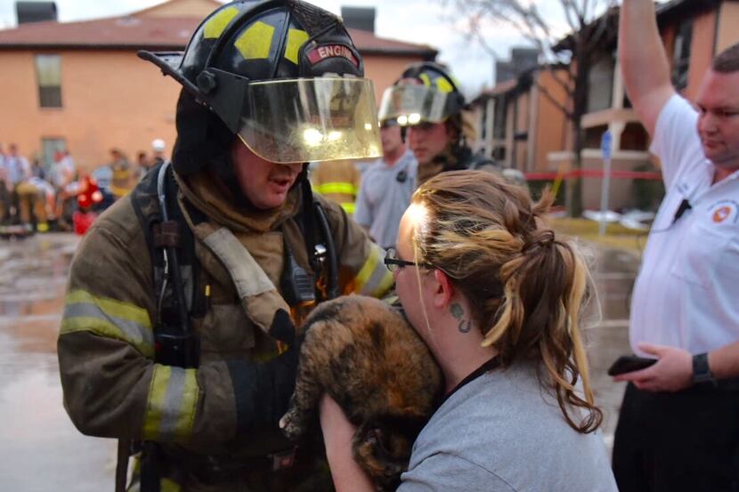  A Fort Worth firefighter returns a cat to its owner after fire in the 5700 block of...