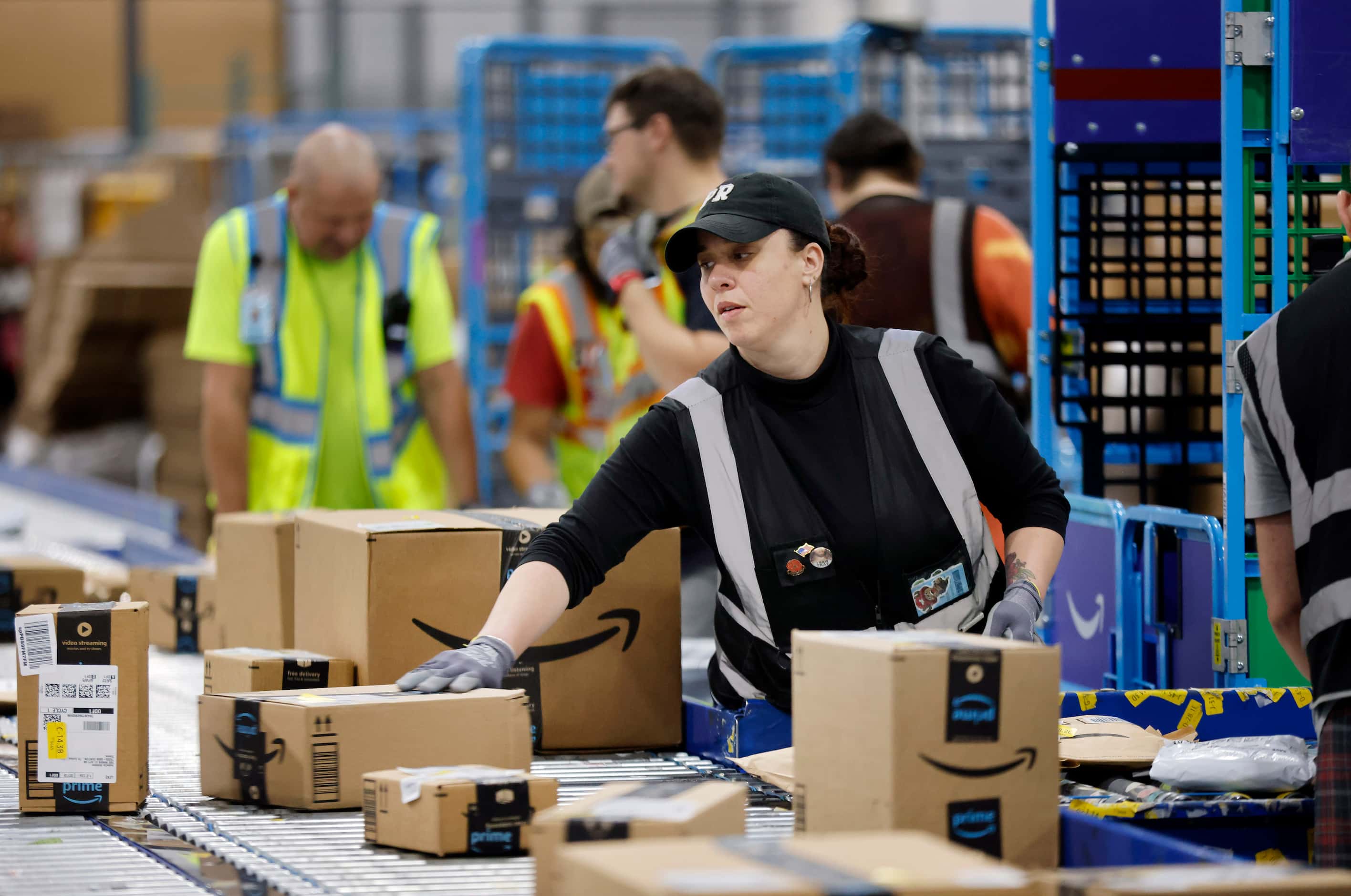 Crew members sort early PRIME day deal packages as they arrive at one of the country’s...
