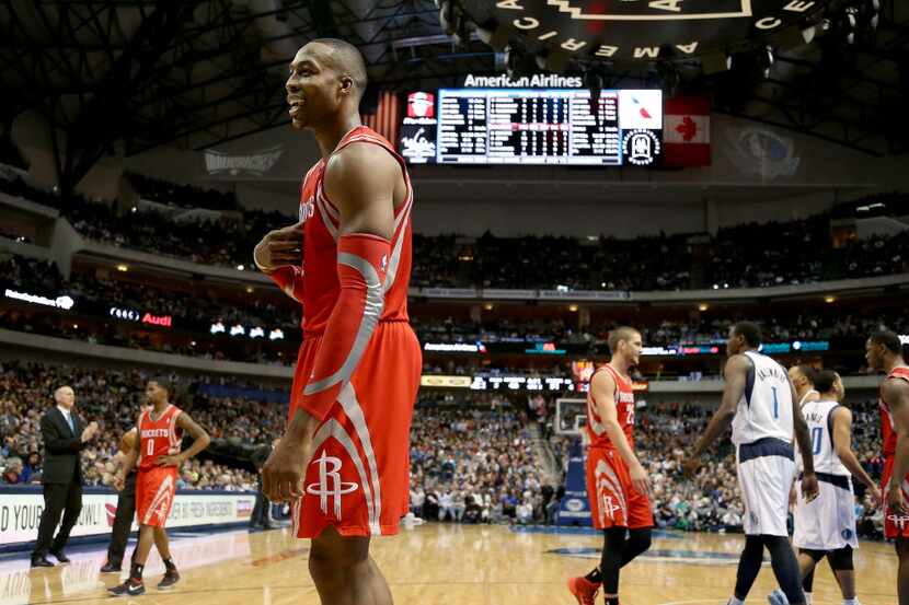 Houston Rockets center Dwight Howard (12) jaws with Dallas Mavericks owner Mark Cuban in the...