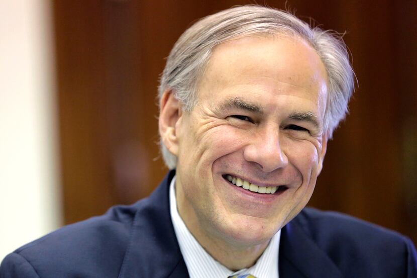 Texas Gov. Greg Abbott shares a laugh with news reporters during a round table talk in his...