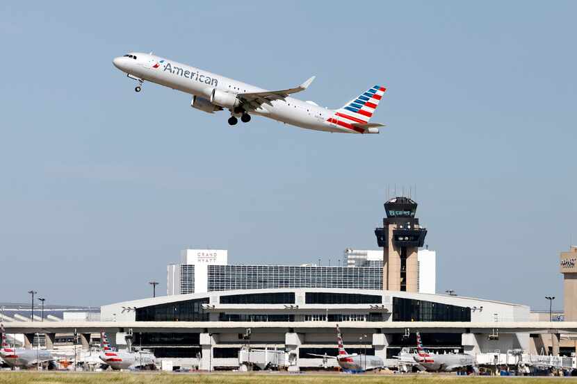 An American Airlines jet takes off above DFW International Airport's Terminal C on Aug. 11,...