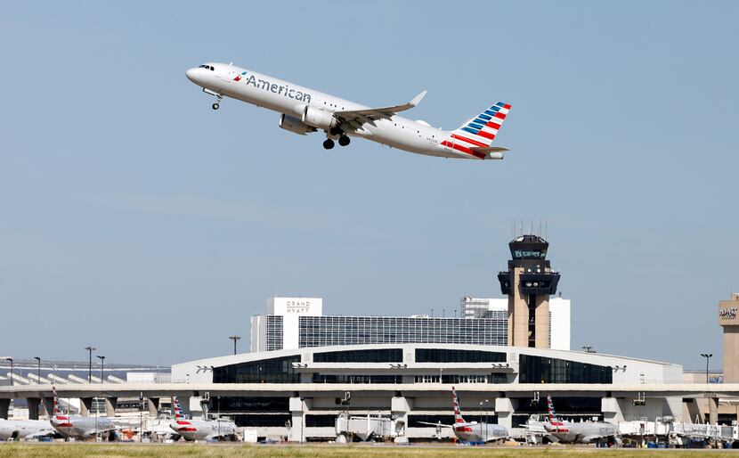 An American Airlines jet takes off above DFW International Airport's Terminal C on Aug. 11,...