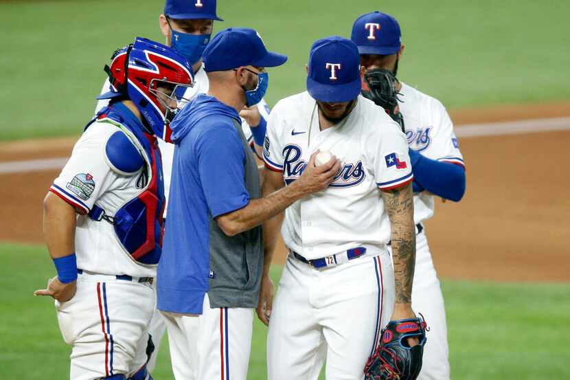 Texas Rangers manager Chris Woodward taps relief pitcher Jonathan Hernandez (72) on the...