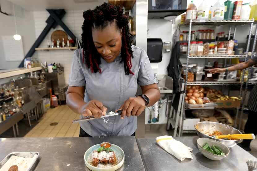 Chef Tiffany Derry grates cheese over the suppli that she made, at her restaurant Roots...
