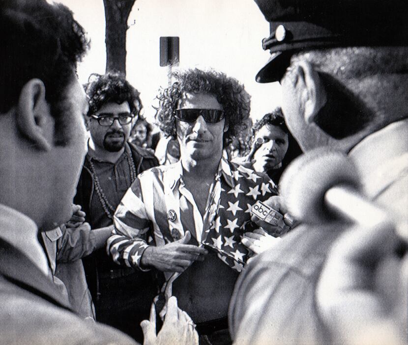 1968 -- Yippie founder Abbie Hoffman, wearing a shirt of flag design, is stopped on Capitol...