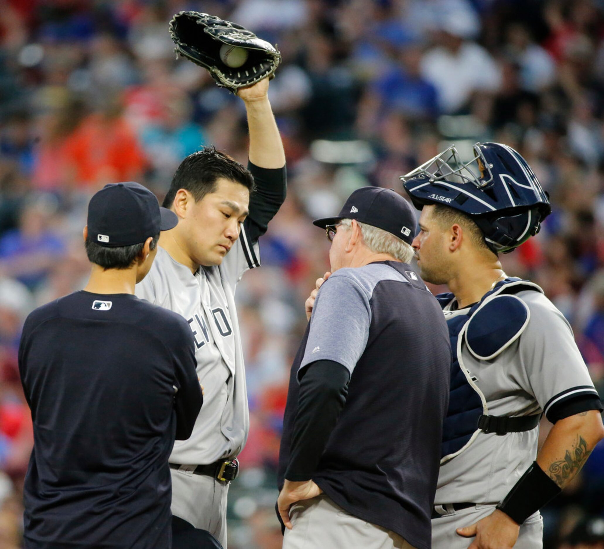 New York Yankees starting pitcher Masahiro Tanaka (19) gets a visit as he struggles in the...