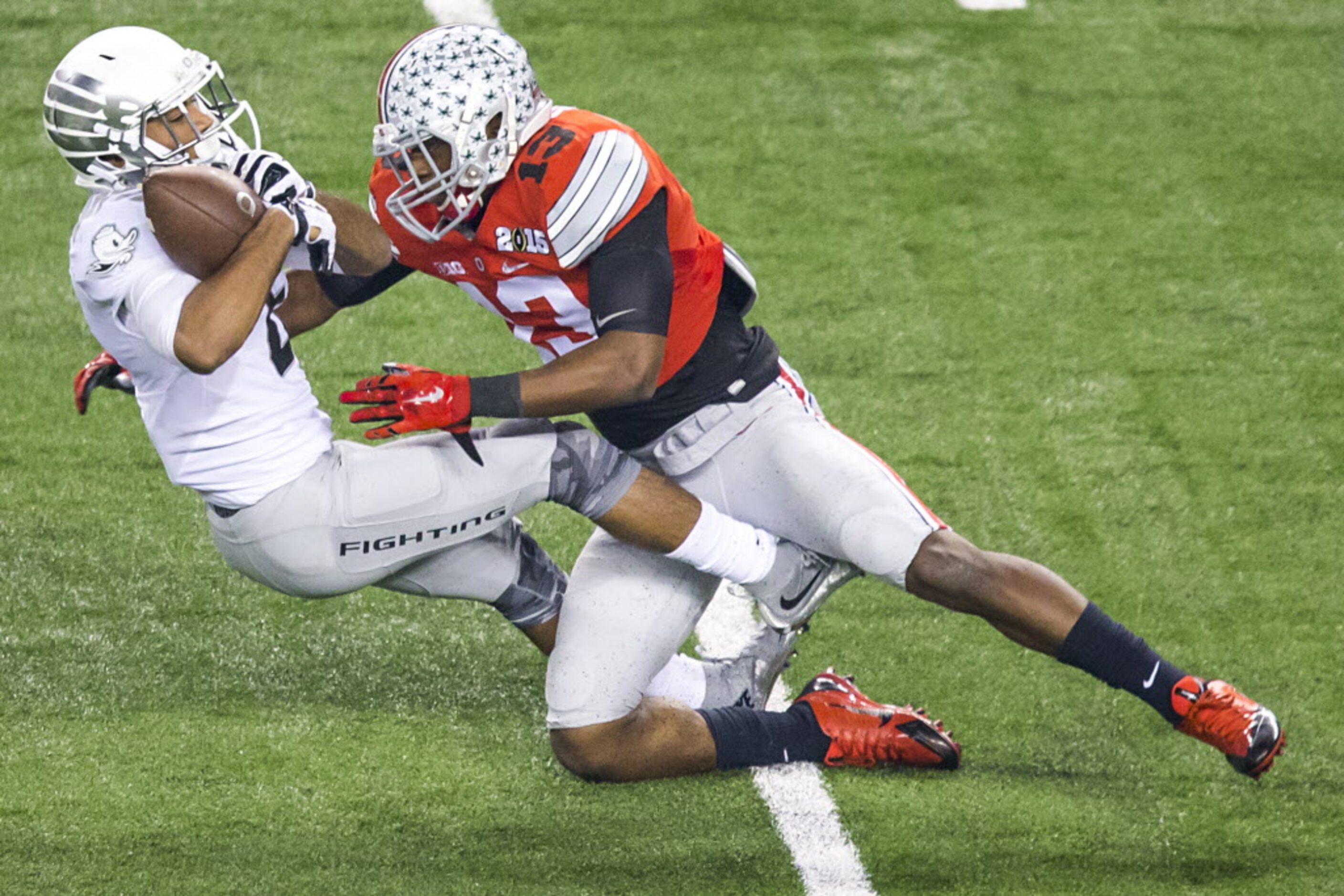 Oregon Ducks wide receiver Charles Nelson (6) is knocked off his feet by Ohio State Buckeyes...