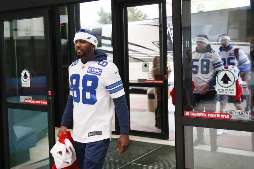 Dallas Cowboys wide receiver Dez Bryant enters while carrying a sack of gifts for patients...