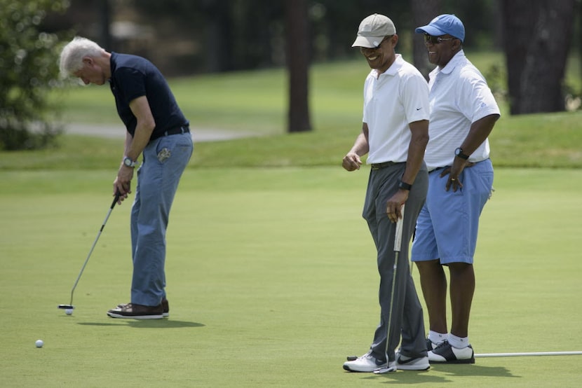  President Barack Obama and Ron Kirk talk as former President Bill Clinton putts at Farm...