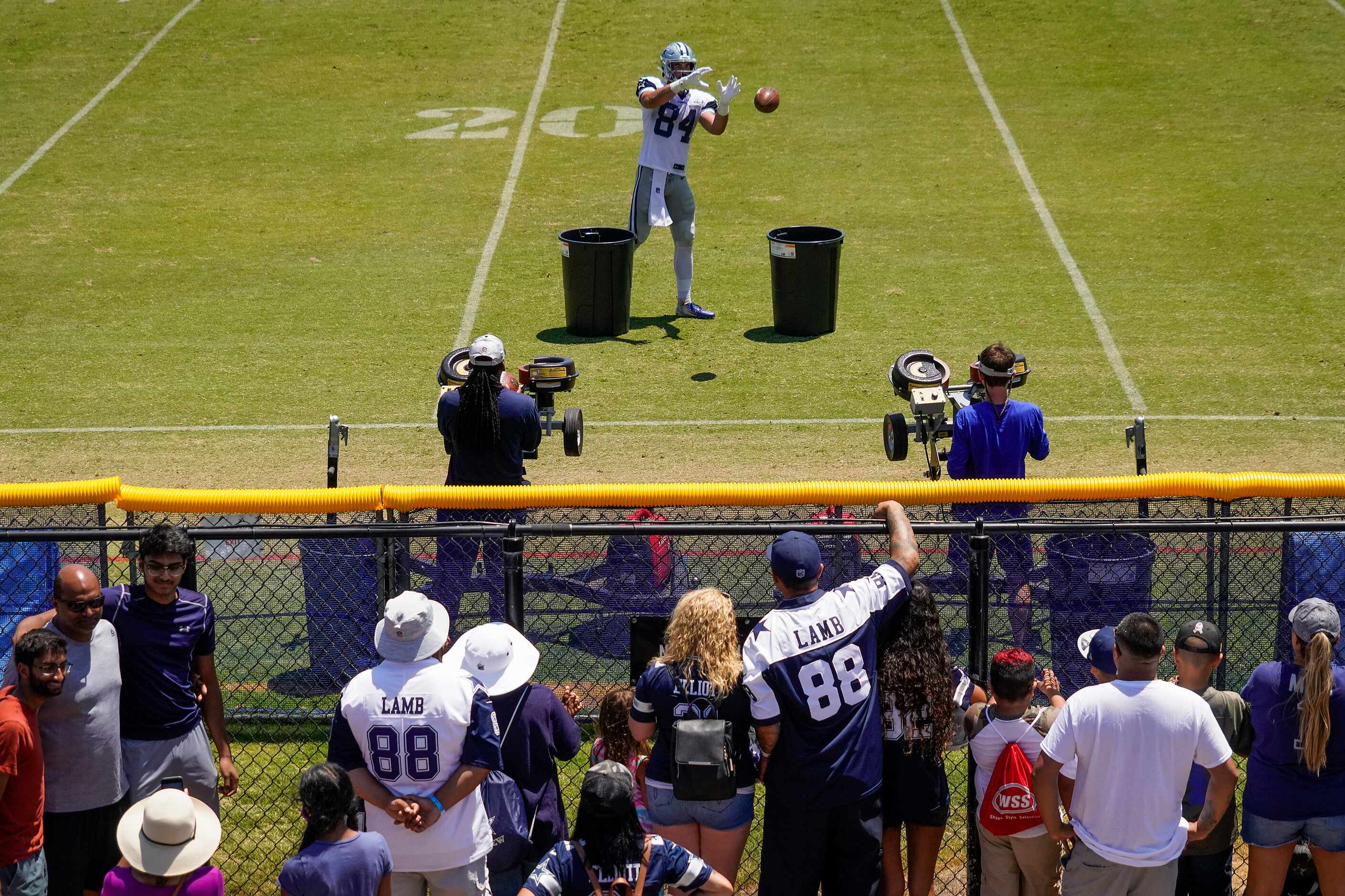 Dallas Cowboys fans press against a fence to get watch tight end Sean McKeon (84)...