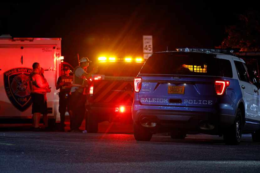 Law enforcement personnel gather at a command post in eastern Wake County, N.C., on Thursday.