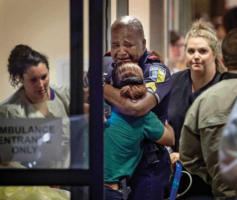  A Dallas Area Rapid Transit police officer receives comfort at Baylor University Hospital...