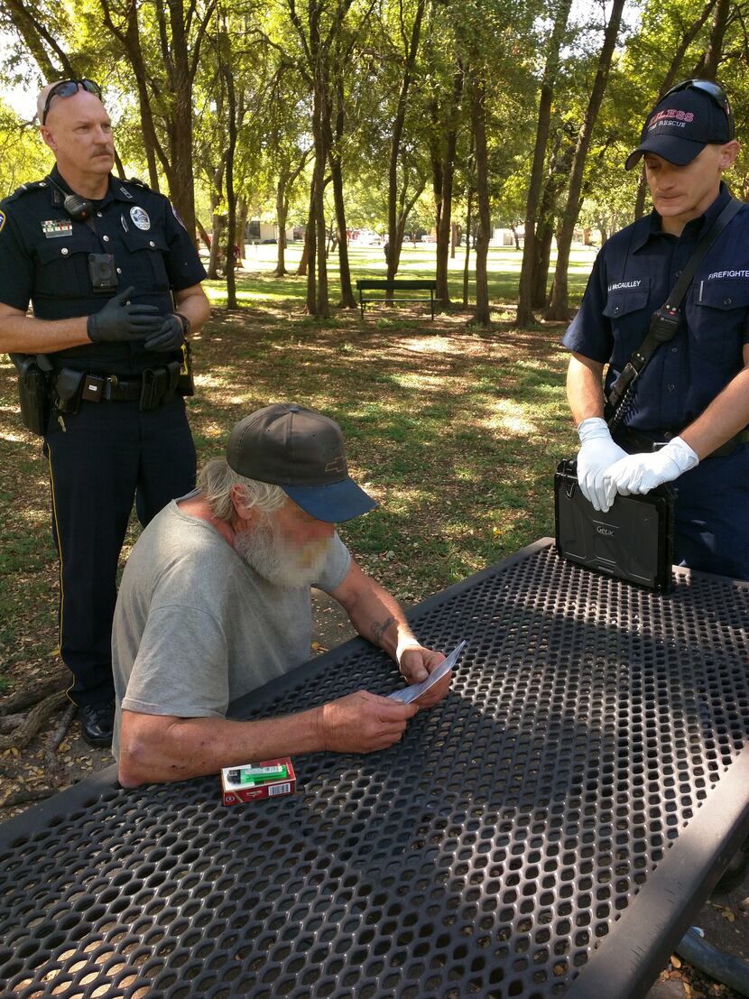 Euless Officer Casey Sanders (left), andan  EMT (right) speak with Floyd (center) about his...